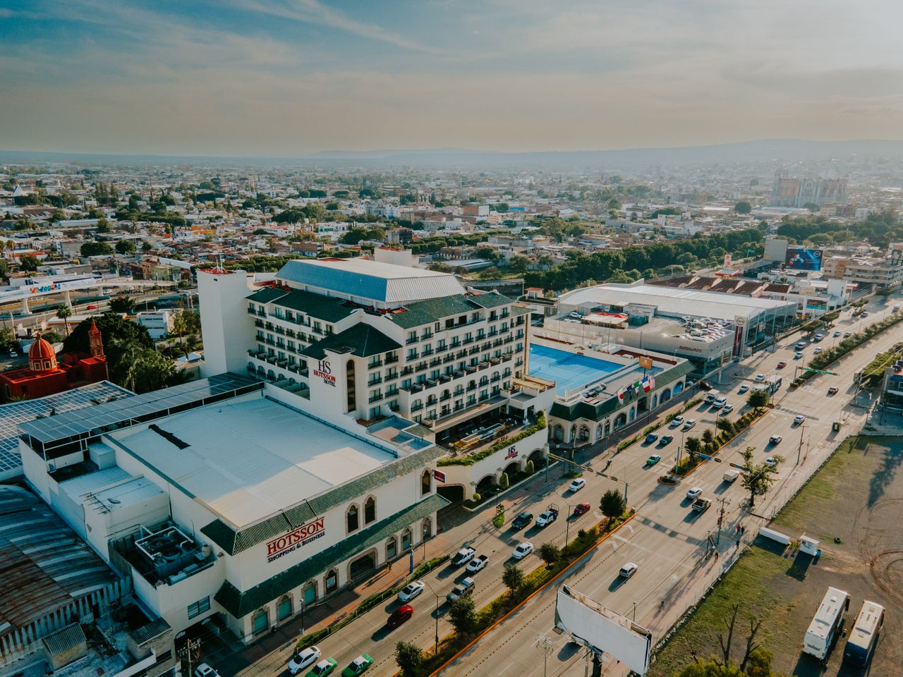 Home Drone shot capturing a vibrant cityscape with prominent hotel and busy highway.